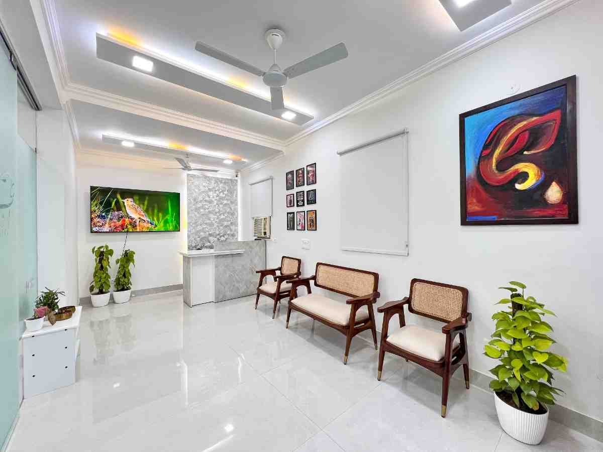 Dental World clinic waiting lounge with rattan chairs, wall art and marble reception desk