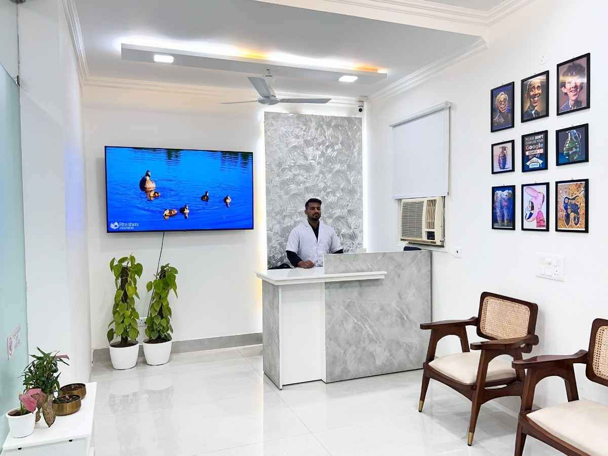 Dental World receptionist at marble front desk with wall decor and TV